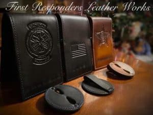 Three leather Badge Holder (Loop) pouches with embossed designs—a medical symbol, U.S. flag, and sheriff’s badge—are displayed on a wooden surface, with additional leather key holders in front.
