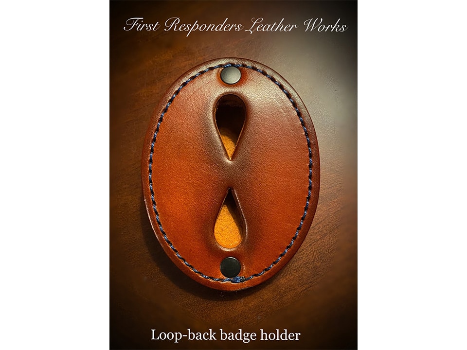 Badge Holder (Loop): Oval leather loop-back badge holder with two metal rivets and stitched edges, shown on a wooden surface. Text is displayed above and below describing the item.